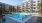 Large sparkling blue pool with a large pool deck and lounge chairs