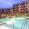 Large sparkling blue pool with a large pool deck and lounge chairs
